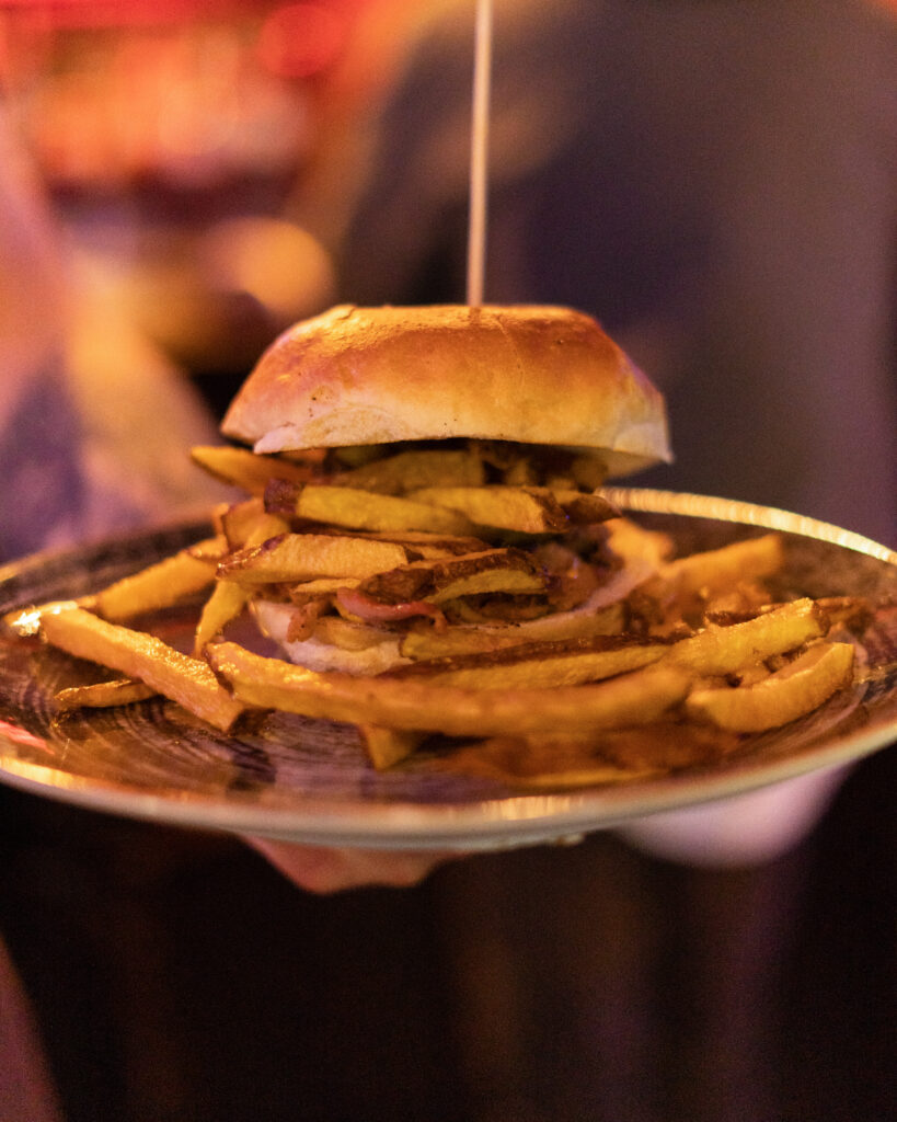 Panino con hamburger e patatine fritte servito nel piatto